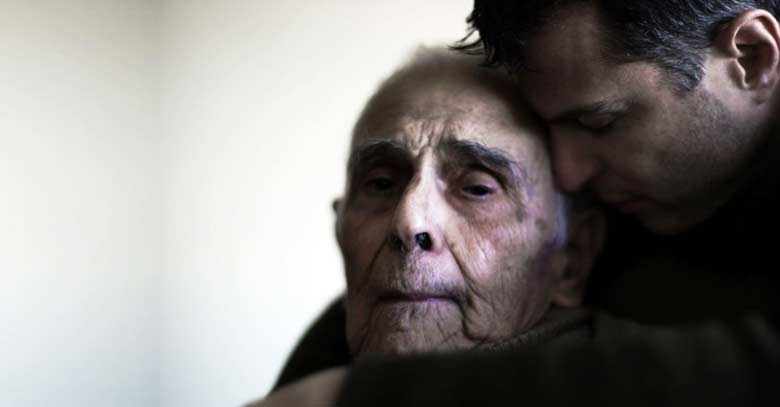 hombre triste abrazando a su padre anciano