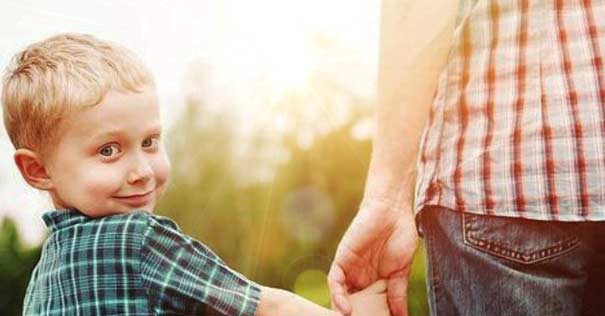 padre hijo tomado de mano nino feliz voltea