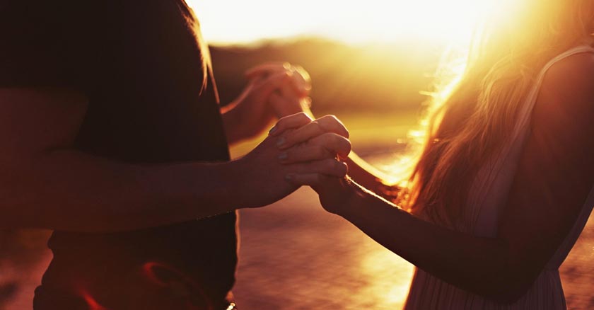 pareja de esposos juntos tomados de la mano ocaso de fondo dia 