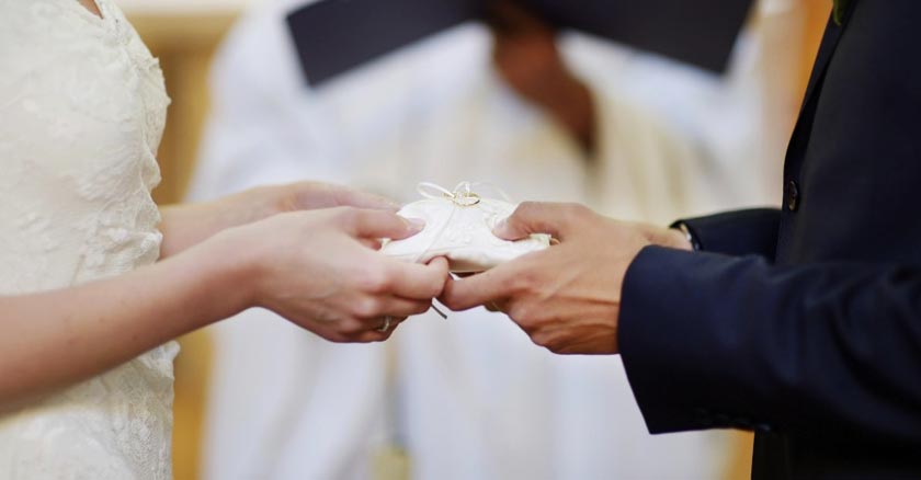 pareja de esposos sosteniendo los anillos en boda de matrimonio dia 