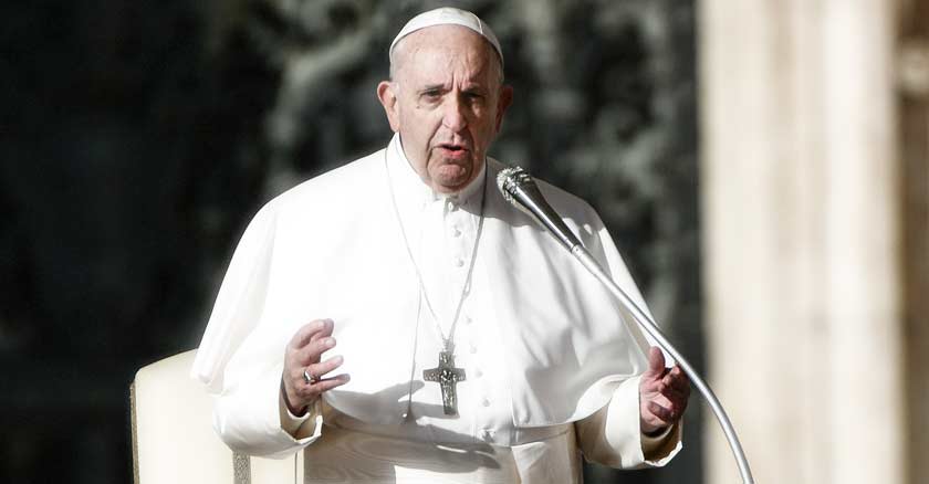 papa francisco hablando de pie con microfono levanta sus dos manos 