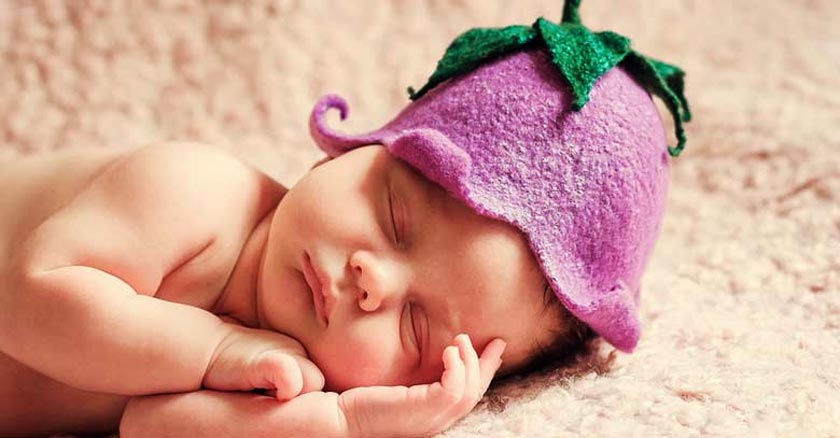 bebe durmiendo una siesta acostado sombrero purpura dia 