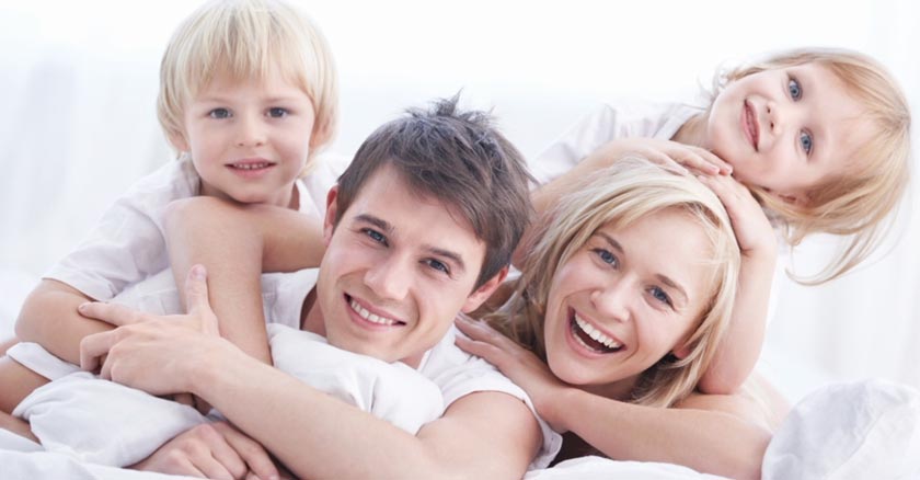 familia esposo esposa hijo hija sonriendo felices acostados fondo blanco dia 