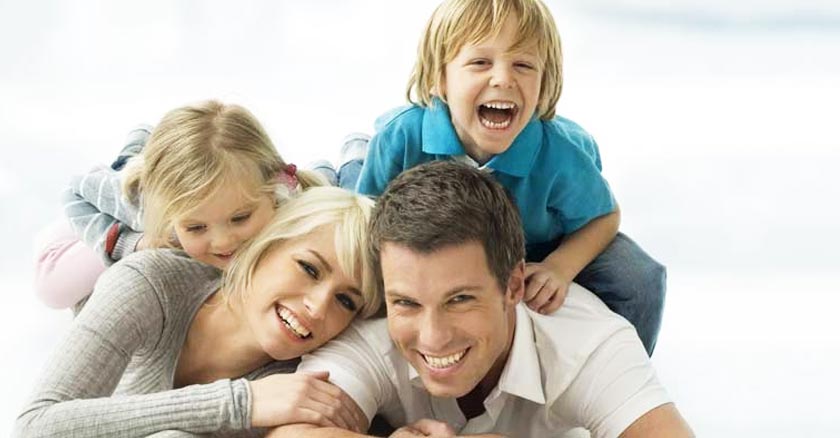 familia matrimonio esposos e hijos sonriendo en el suelo fondo blanco dia 