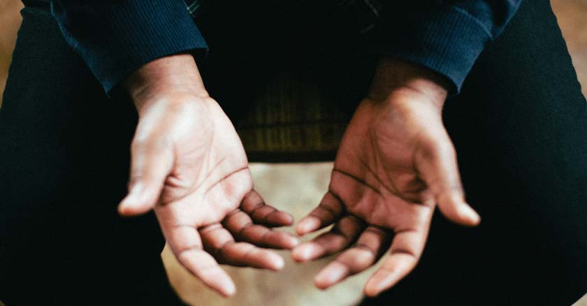 hombre con las manos abiertas en posicion de oracion a Dios