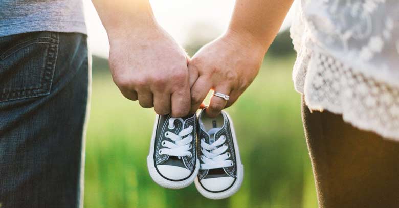 matrimonio esposo esposa tomando de la mano zapatos de bebe 