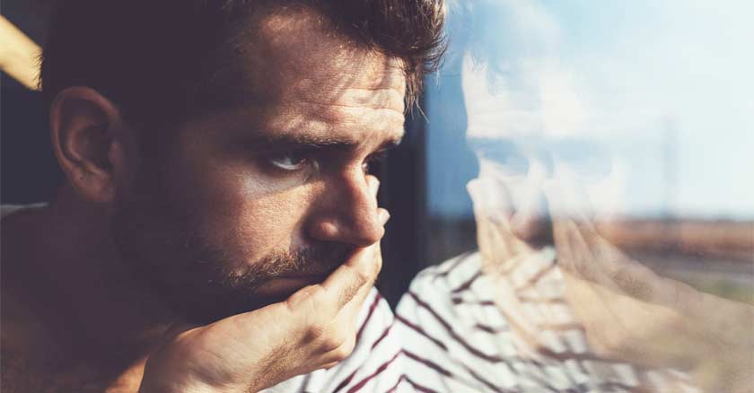 hombre mirando por la ventana rostro preocupado angustiado reflejo