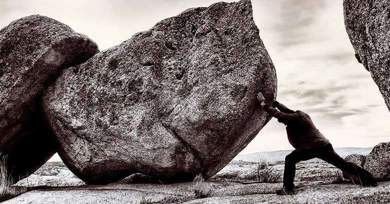 hombre sosteniendo empujando roca gigante