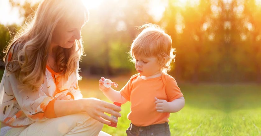 mama jugando con su hijo varon en el parque dia soleado