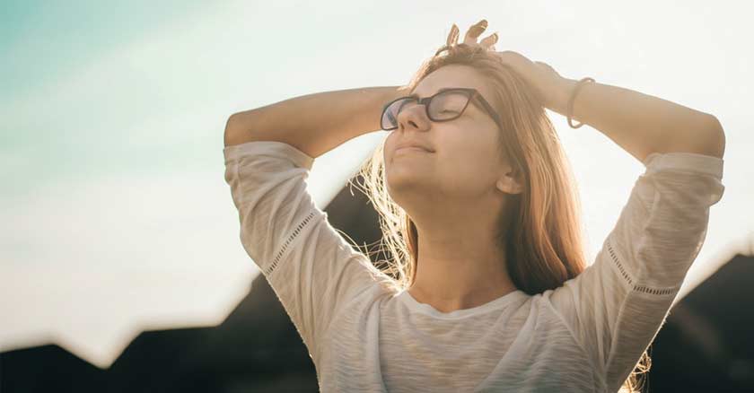 mujer relajda con los ojos cerrados al aire libre fondo naturaleza