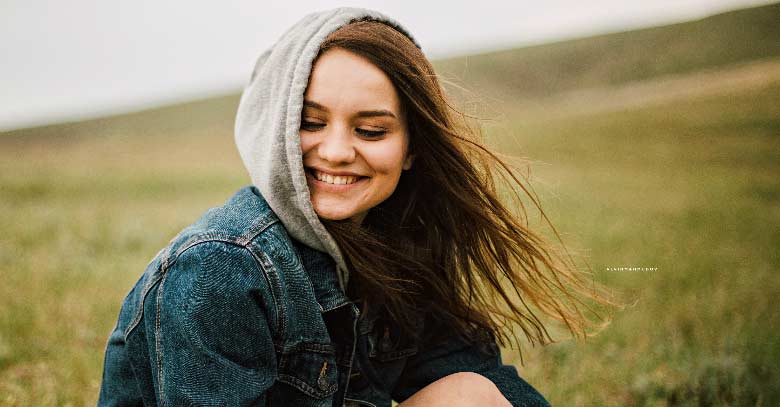 mujer sonrie feliz pradera